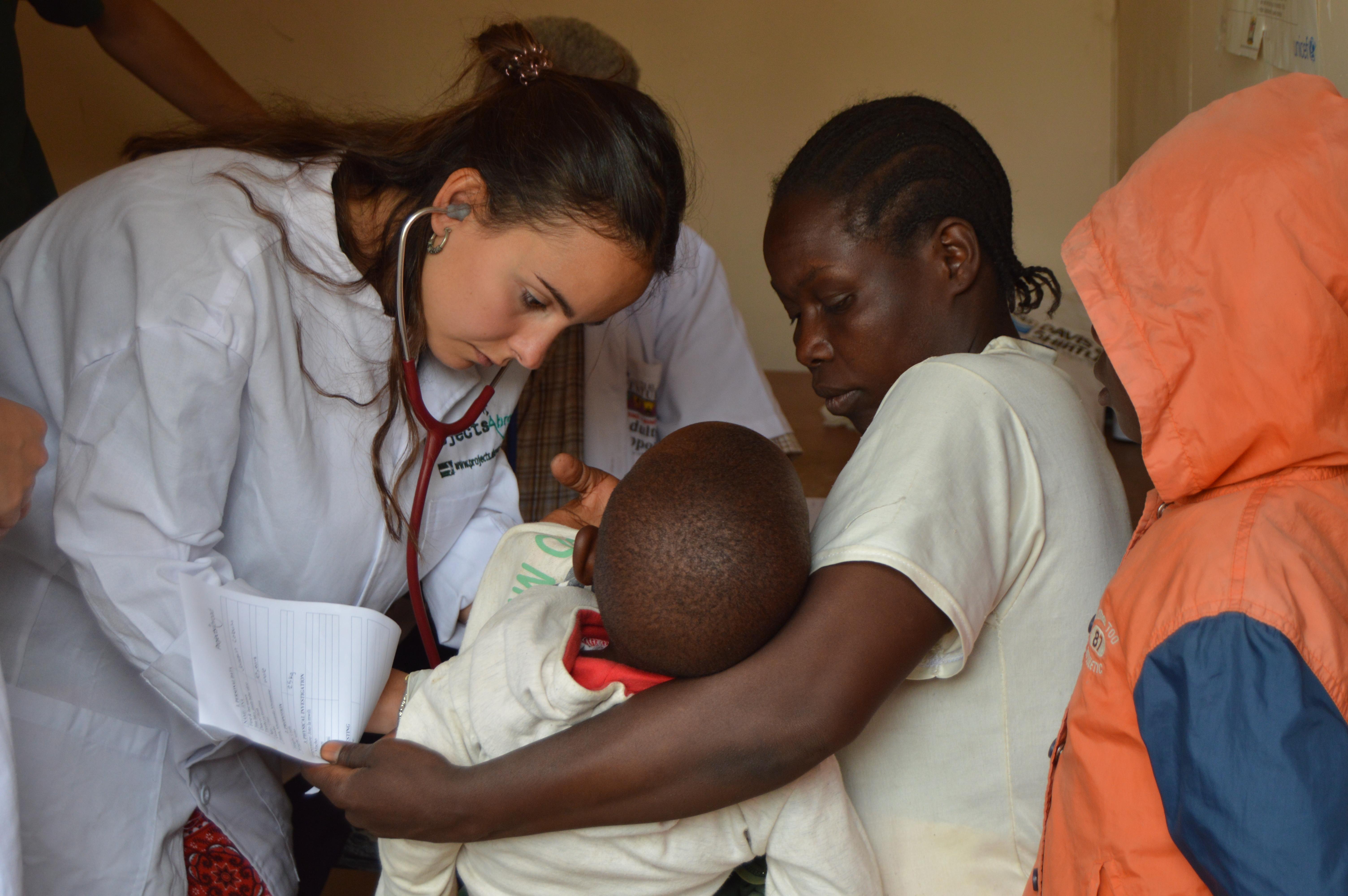 A French intern examining a child during a medical outreach whilst on her nursing internship in Tanzania with Projects Abroad. A French Projects Abroad intern is seen examining a child during a medical outreach whilst she completes her nursing internship in Tanzania.